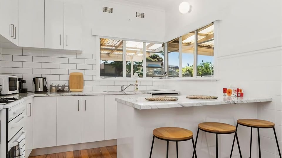 The bright and modern family kitchen, perfect for preparing holiday dinners or big breakies featuring a central breakfast bar,