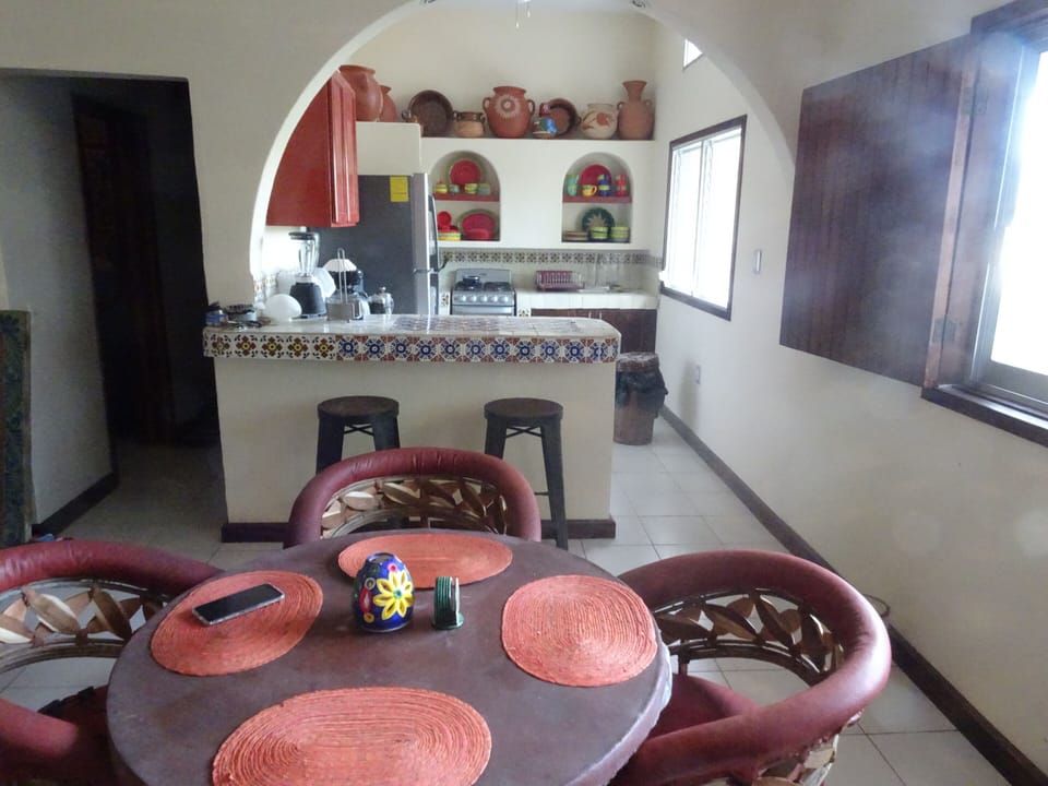Dining table and bar with stools,  looking into the kitchen