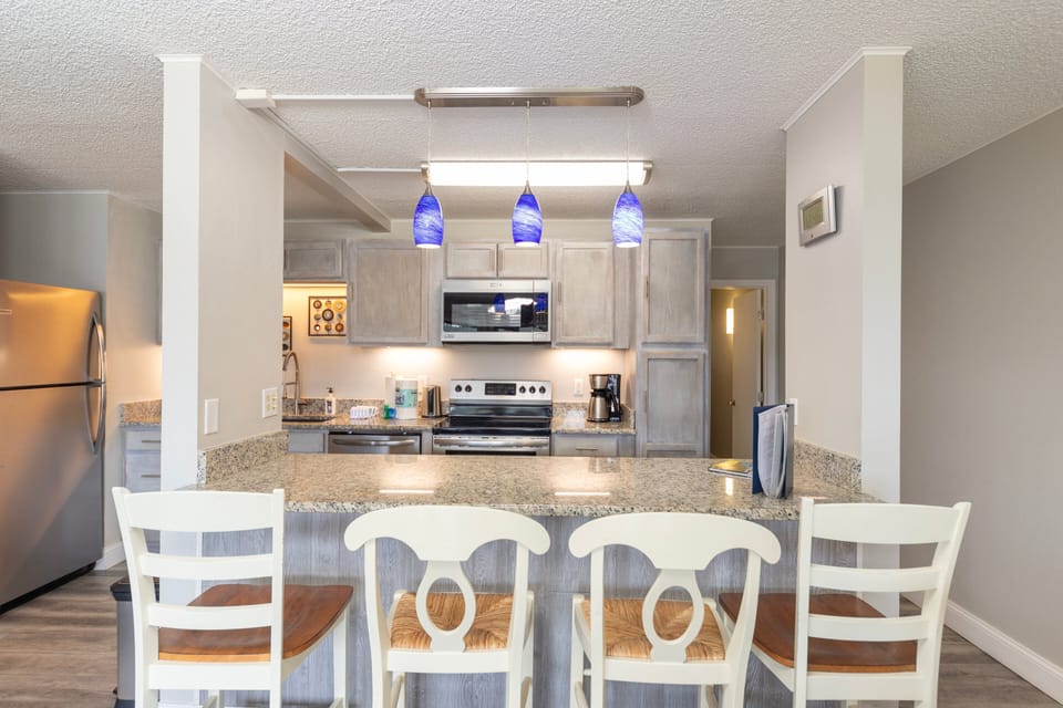 Full kitchen with bar seating area.