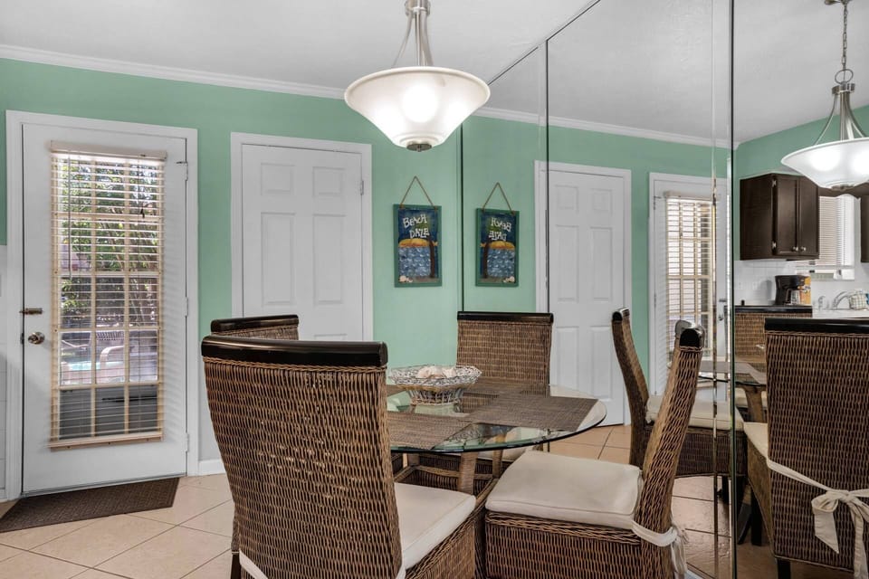 A dining table with four chairs sits near the kitchen and living room.