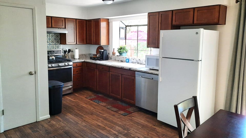 Fully stocked kitchen with gas range, microwave, dishwasher.
