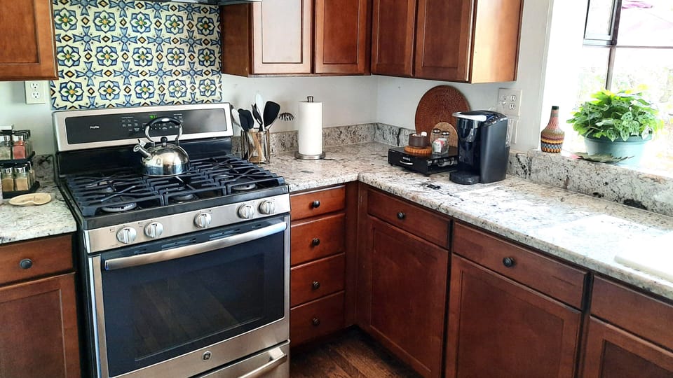 Fully stocked kitchen with gas range, microwave, dishwasher.