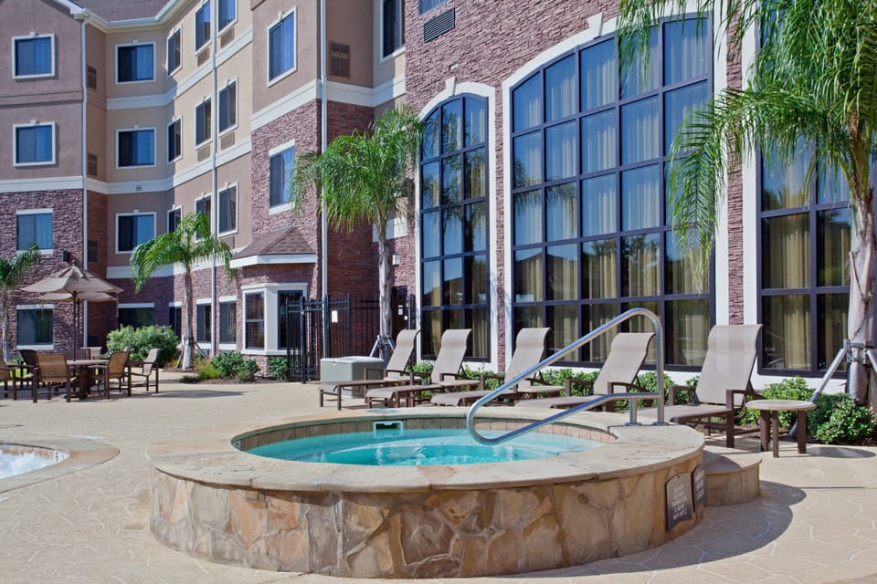 Outdoor hot tub with lounge chairs nearby.