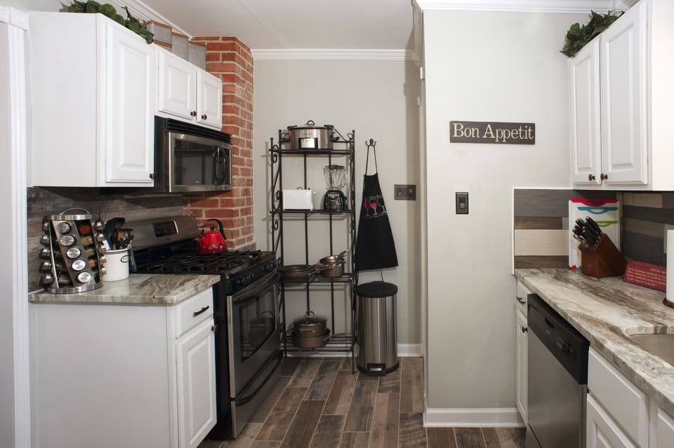 Kitchen is complete with cookware, dishwater, and spice rack. 