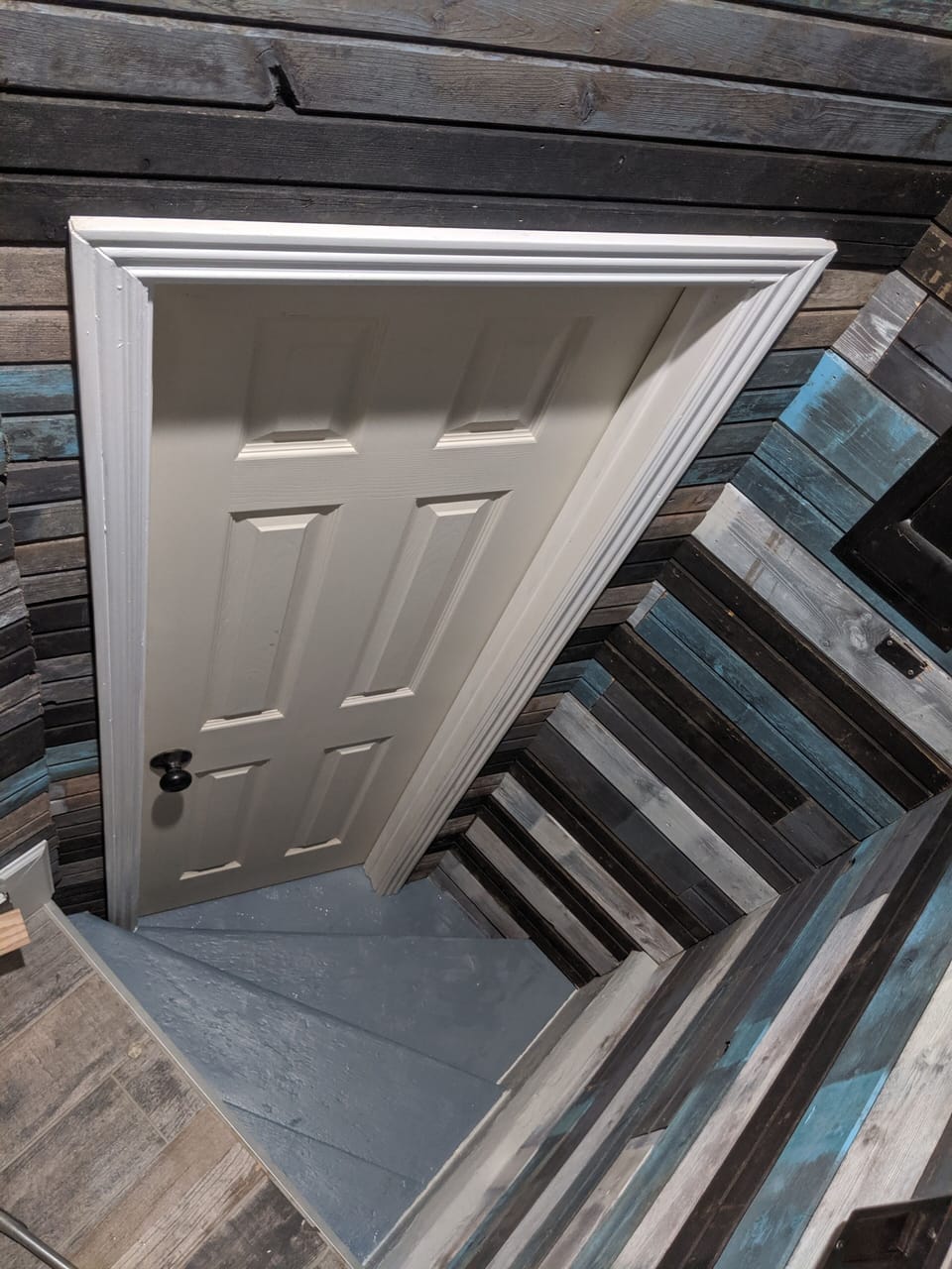 Stained barn wood door leads to basement laundry. 