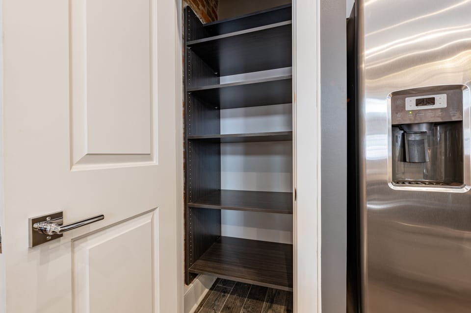Galley-style, fully equipped kitchen with an open flow to the living/dining area. Stocked with essentials from mixing bowls to wine glasses, featuring stainless steel appliances, stone countertops, and a tile backsplash for a touch of luxury!