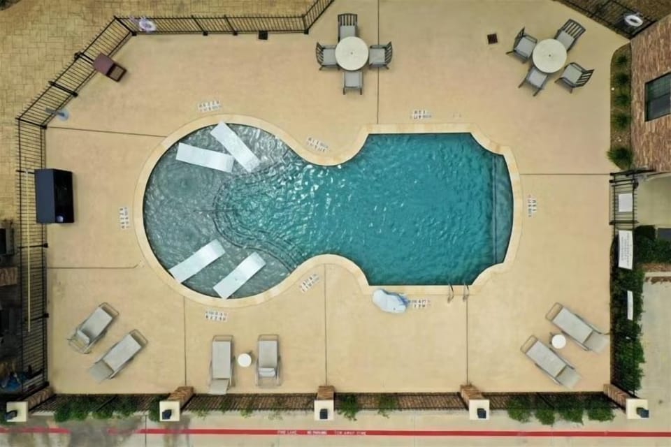 Lounge chairs line the pool deck for a relaxed afternoon in the Texas sun