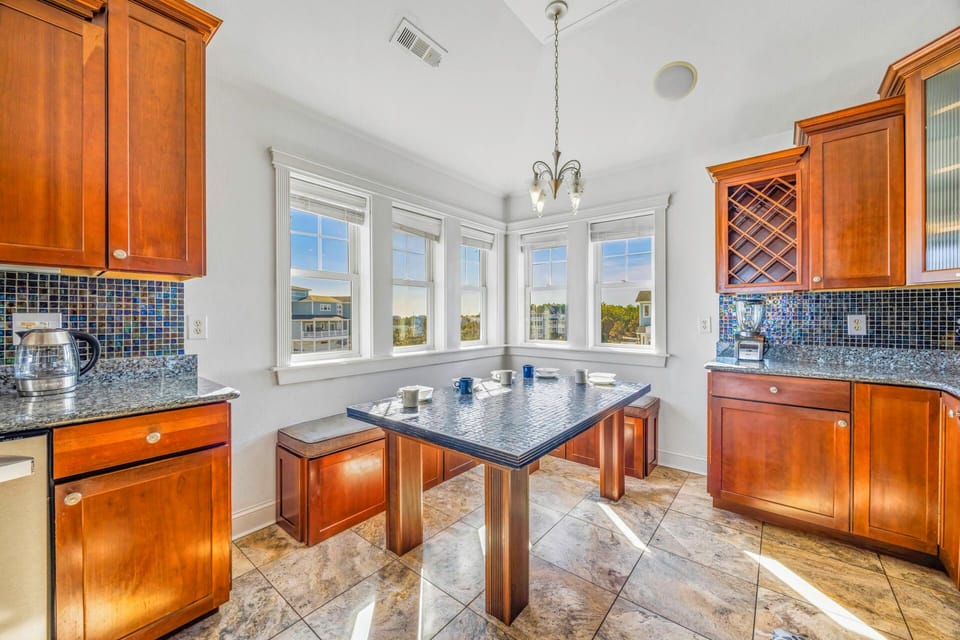 Your kitchen combines rich wood cabinets with stunning granite counters and a mosaic backsplash, perfect for morning coffee by the bright windows.