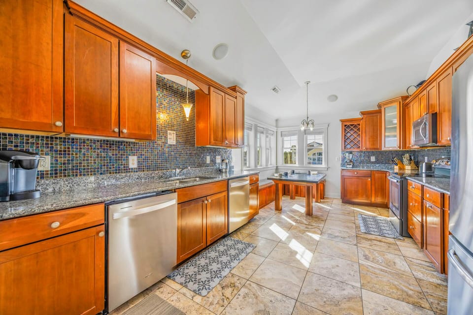 Your gourmet kitchen awaits with rich wood cabinetry, granite counters, and mosaic tile backsplash—perfect for creating memorable meals together.