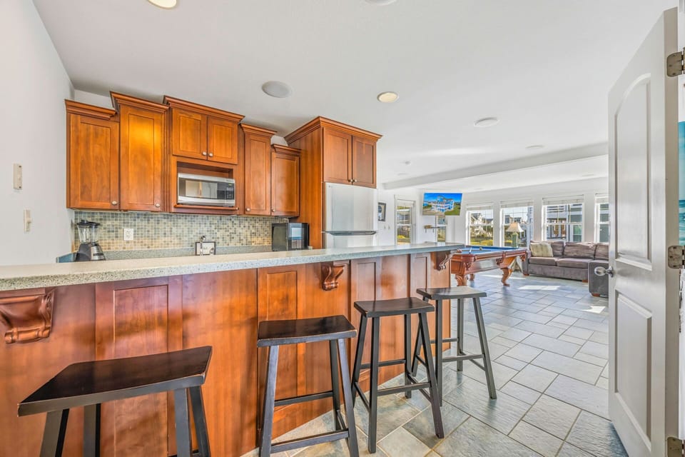 Your spacious open kitchen features warm wood cabinets, granite counters, and a breakfast bar where you can sip morning coffee while sunlight streams through.