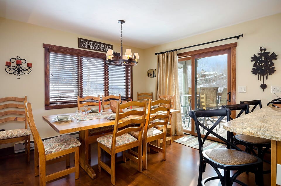 Gather around your welcoming dining table with mountain views through large windows, perfect for sharing meals after skiing adventures.