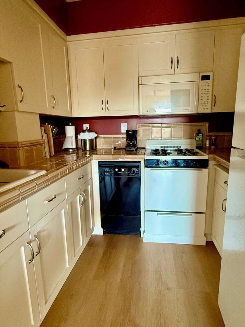Kitchen with dishwasher, stove/oven, microwave, refrigerator, & coffee-maker.