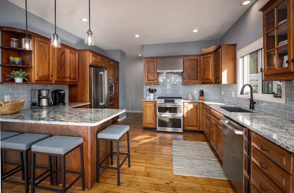 Main level kitchen - High-end granite counters, a gas range, and stainless-steel appliances.