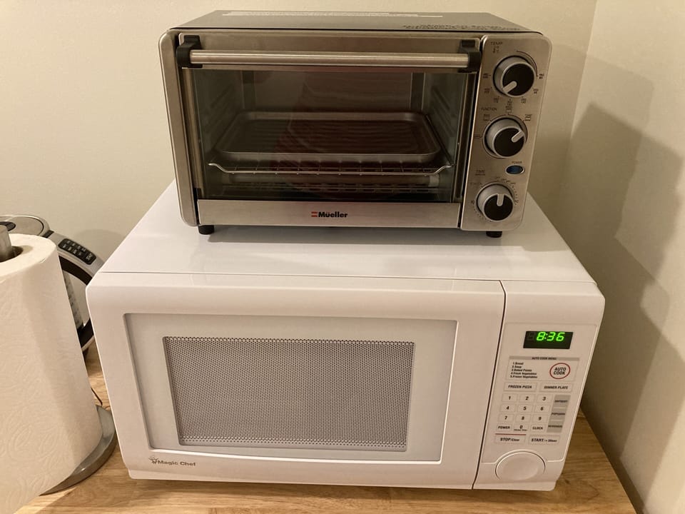 Mini toaster oven/broiler and microwave. Toaster oven bakeware under sink.