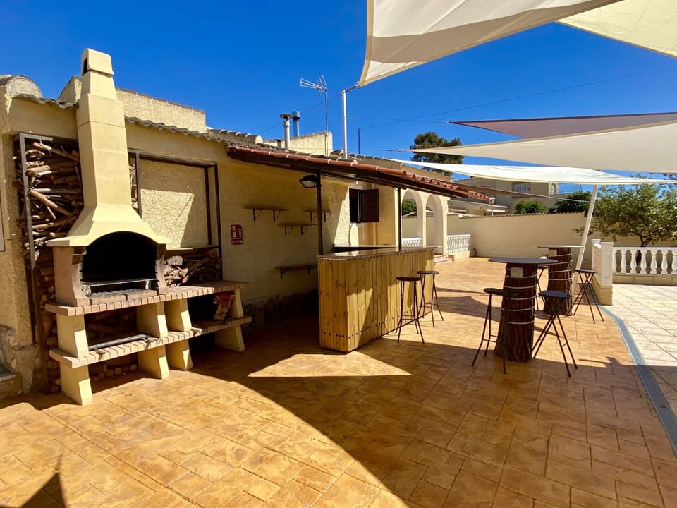 Charcoal BBQ area with full size Bar & dining area next to the pool 