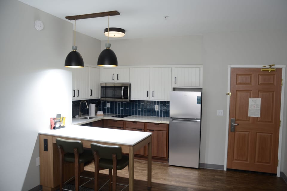 Modern kitchen area with bar seating and full appliances.