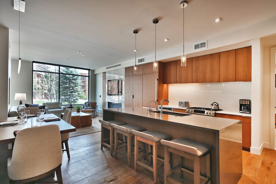 Open floor plan with kitchen, dining, and living area, hardwood floors throughout and extra large picture window for abundant natural light