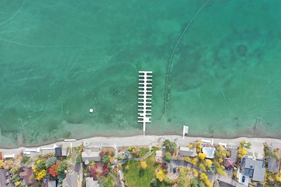 Aerial view of the Mountain Harbor private beach on Whitefish Lake with dock. (Boat slips available with reservation).