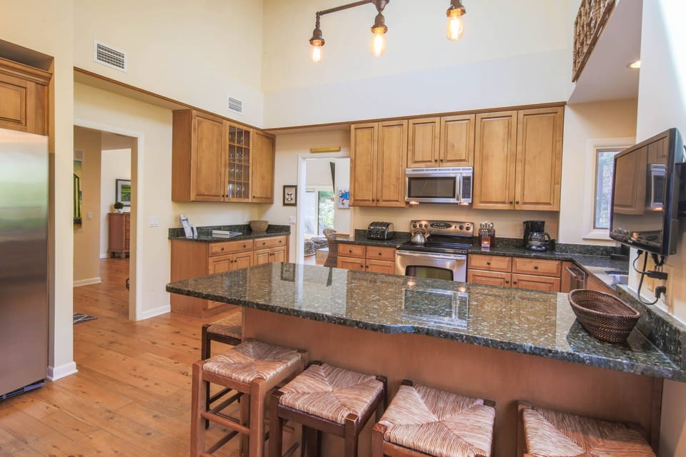 The spacious kitchen features granite countertops, stainless steel appliances and a vaulted ceiling.