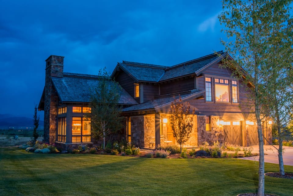 Your stunning retreat glows warmly against the evening sky, where rustic stone and timber blend beautifully with modern comfort. Step into your private sanctuary surrounded by lush gardens.