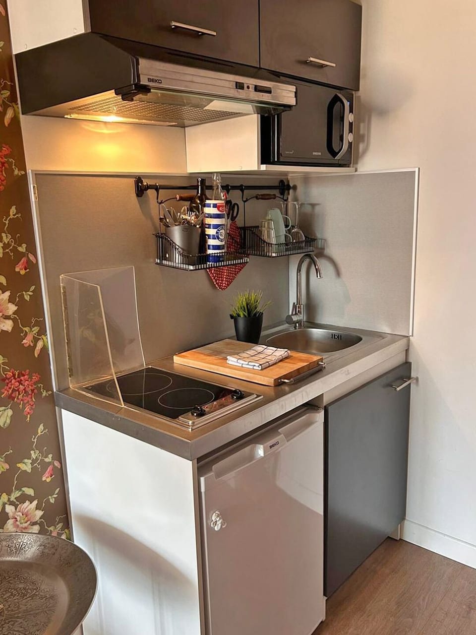 The kitchenette has a stove, a fridge and a microwave.