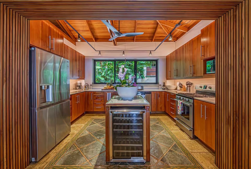 Warm wood kitchen with jungle views creates a relaxed cooking space