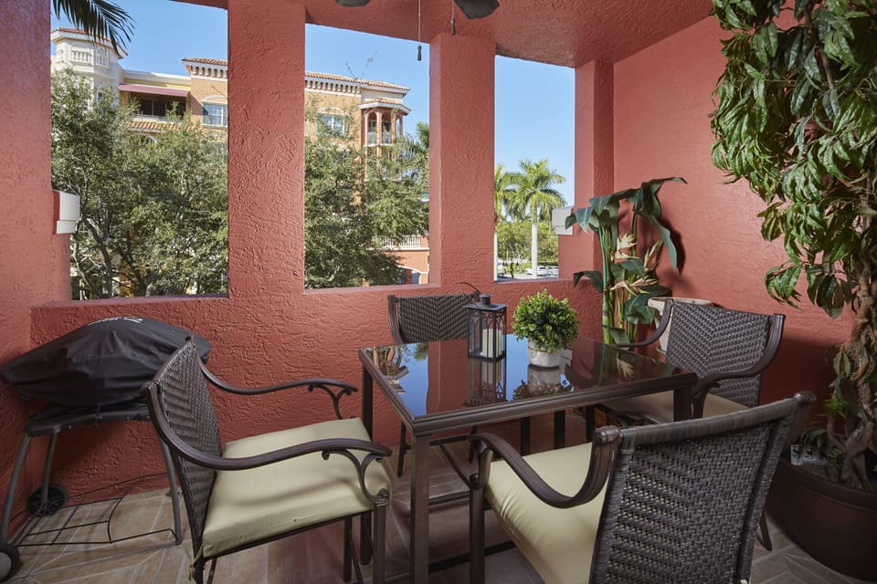 Lania off sitting room with high-top table, chairs, and electric grill.
