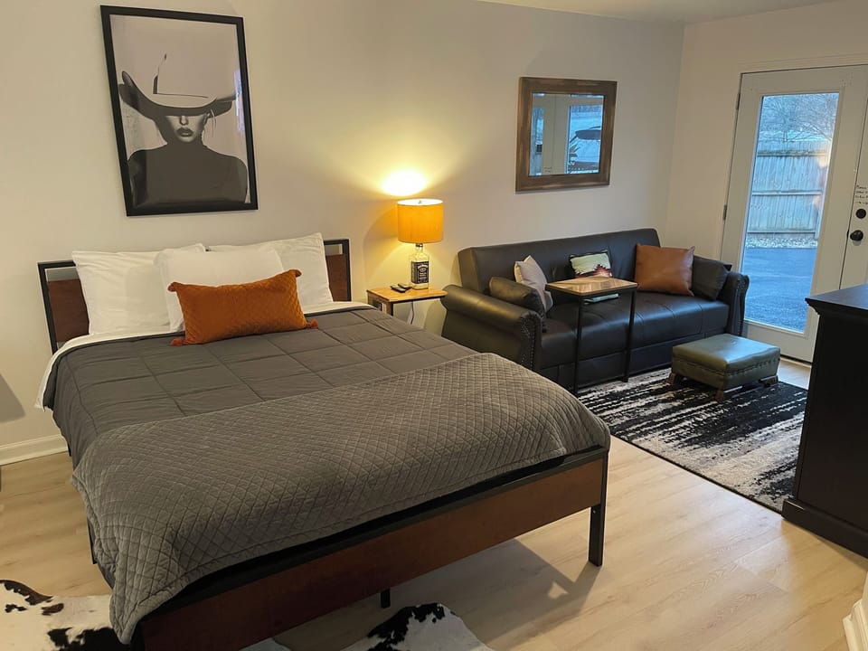 Large bedroom with smart tv, fireplace and couch