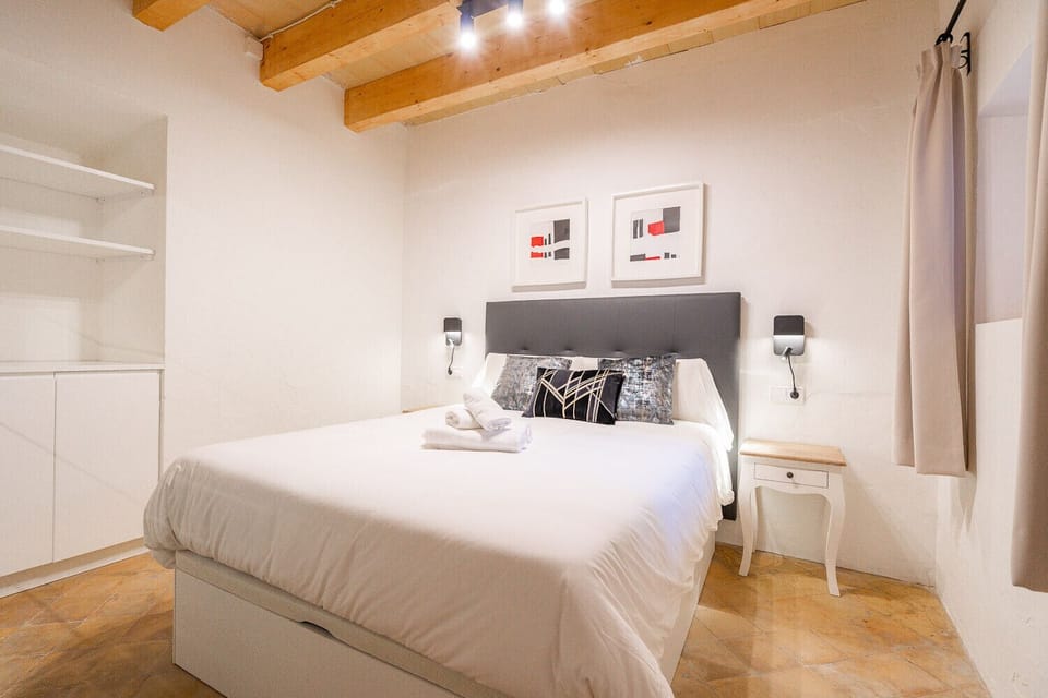 Bedroom of the Vintage Palma Palace vacation rental apartment, apartment 3. It has a double bed and two bedside tables, with a large wardrobe where you can store your clothes and a TV.
