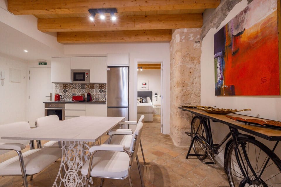This holiday apartment in Palma's city center has got everything you need for having a great stay. Here you can see the dining room and kitchen, and the bedroom at the end.