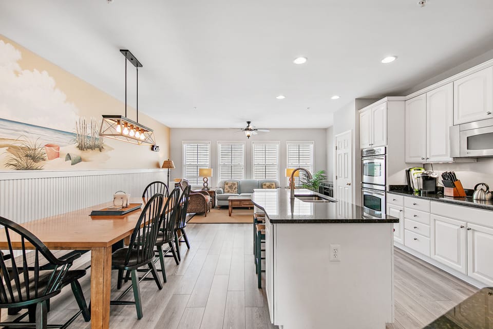 Closeup view of kitchen - large table and island for family meals with sunroom.