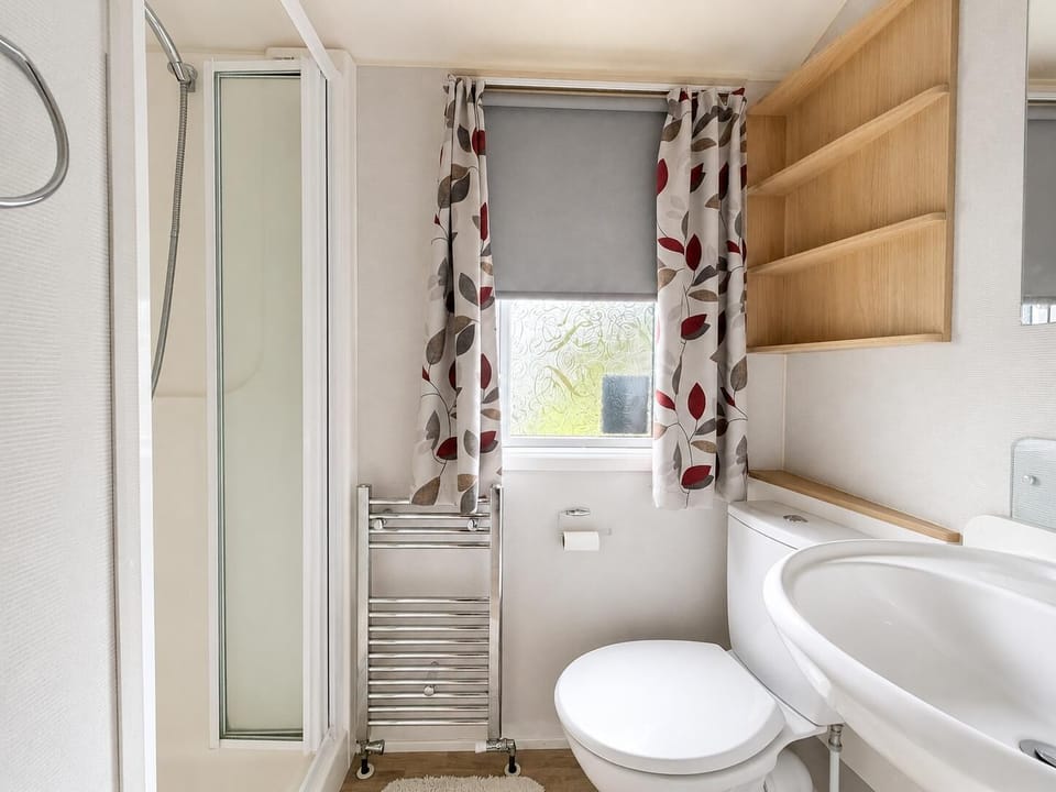 Shower room features a glass door enclosure a great addition to the caravan.