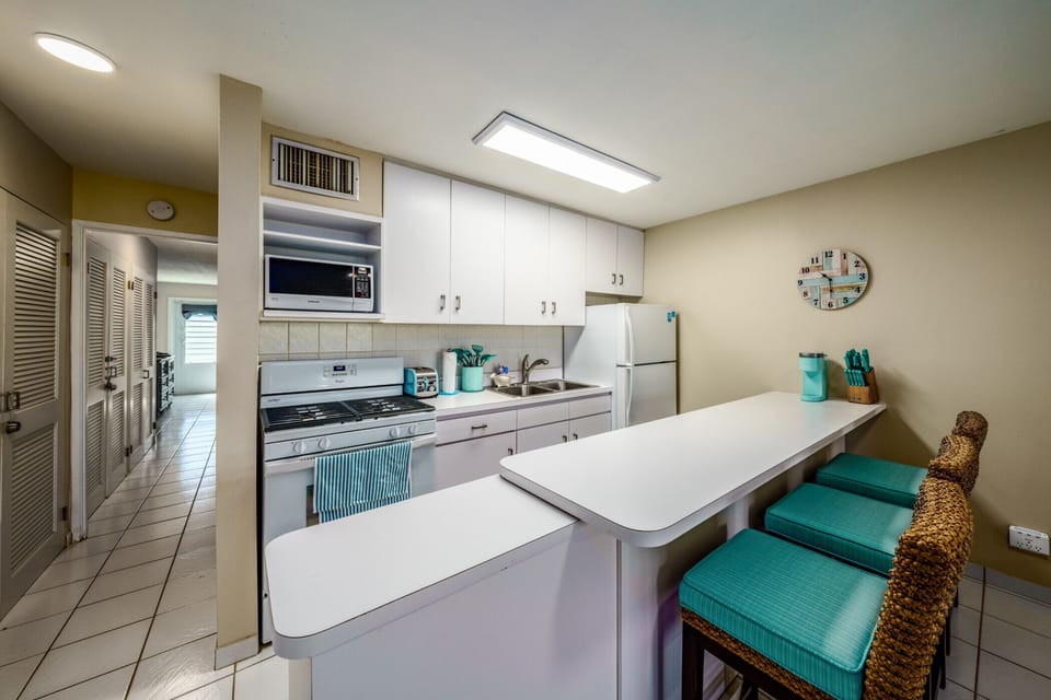 The well-appointed kitchen with bar and bar stools.