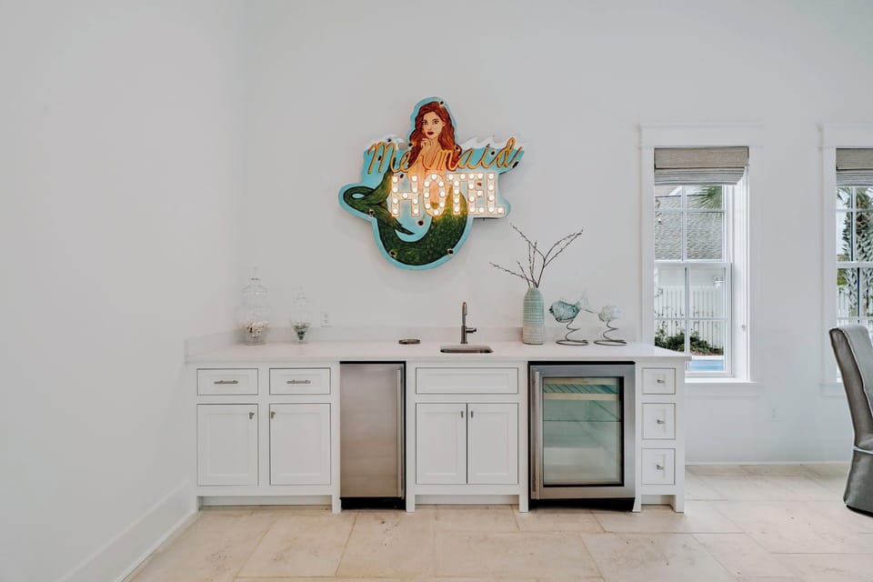 Your stylish wet bar features a wine fridge and dishwasher, perfect for entertaining while enjoying coastal charm.