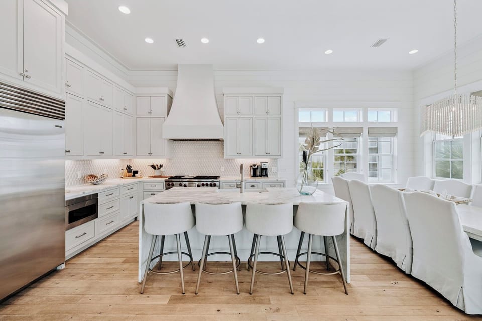 Gather in this stunning white kitchen with marble island and modern appliances, perfect for cooking and entertaining.