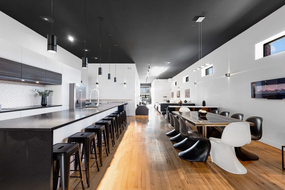 Dining Room: This space features three sections: a luxurious formal dining table, a cozy breakfast table, and a large island with bar seating. Perfect for large group events or multiple groups, it also includes a fireplace, fully equipped for stylish meal