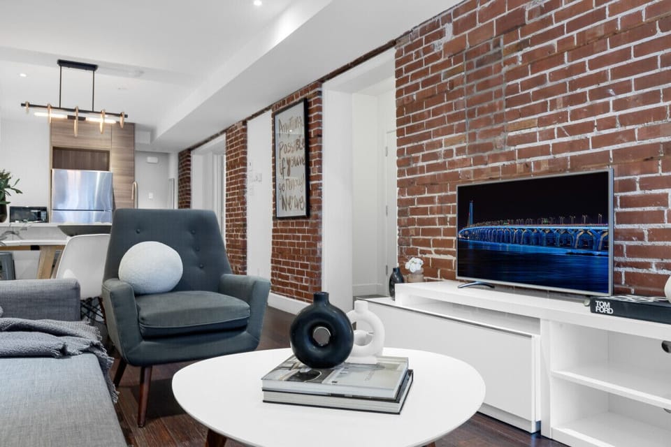 Living Room: Features a queen-size sofa bed with Art Deco design, two armchairs, and a Smart HD TV with access to Netflix, YouTube, and Prime.