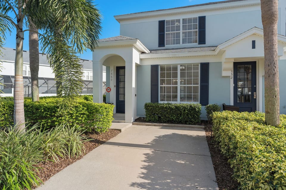 Front of the home with dedicated parking for one car, more parking to the left