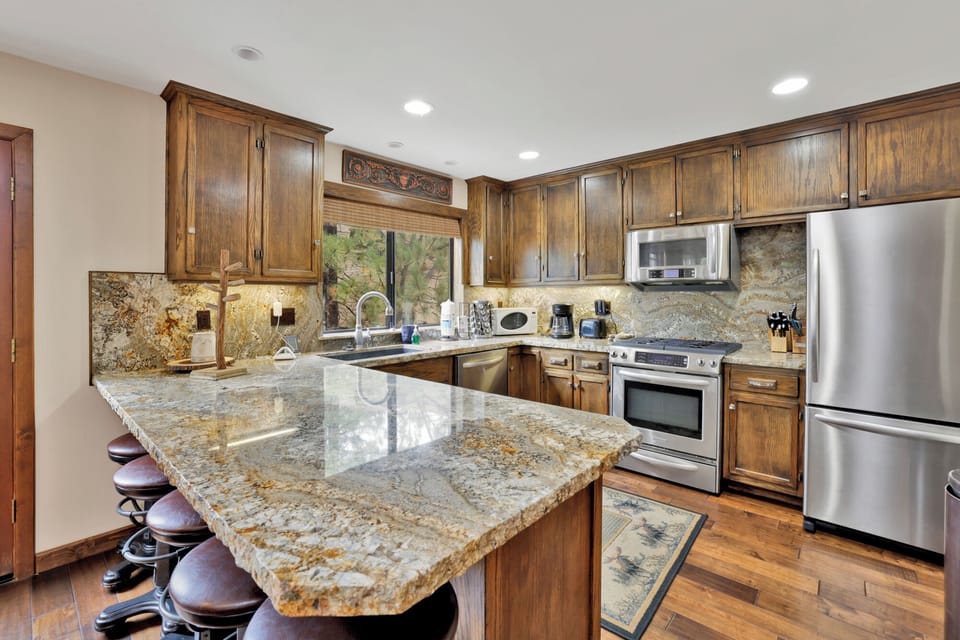 Fully equipped cabin kitchen with ample cabinetry, stove, fridge, microwave, and coffee maker—perfect for cooking meals, morning coffee, and feeling right at home on your stay.