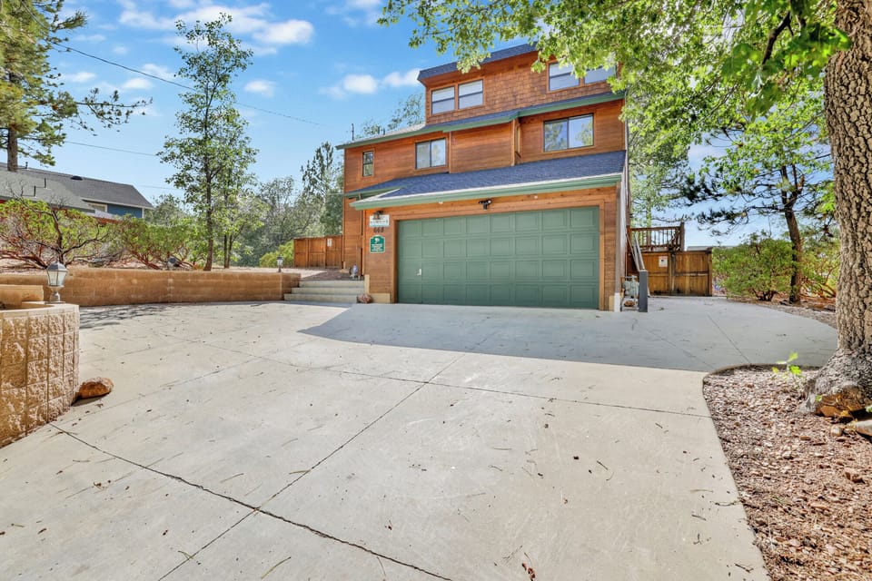 Welcoming cabin entry surrounded by towering pine trees, offering fresh mountain air and a peaceful forest setting—the perfect first impression for your Big Bear Lake getaway.