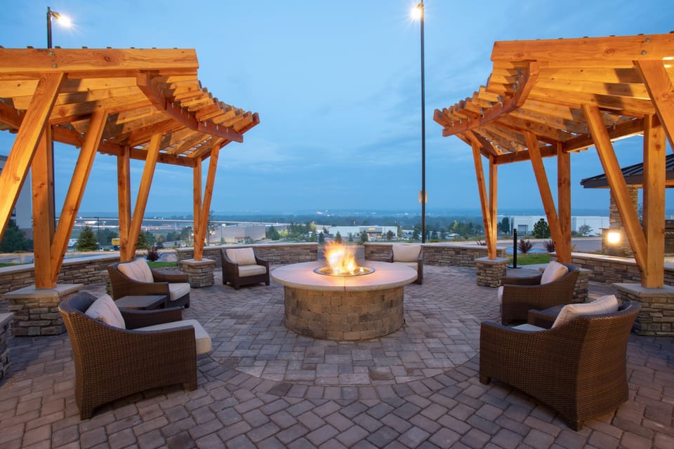 Outdoor patio with fire pit and lounge seating.