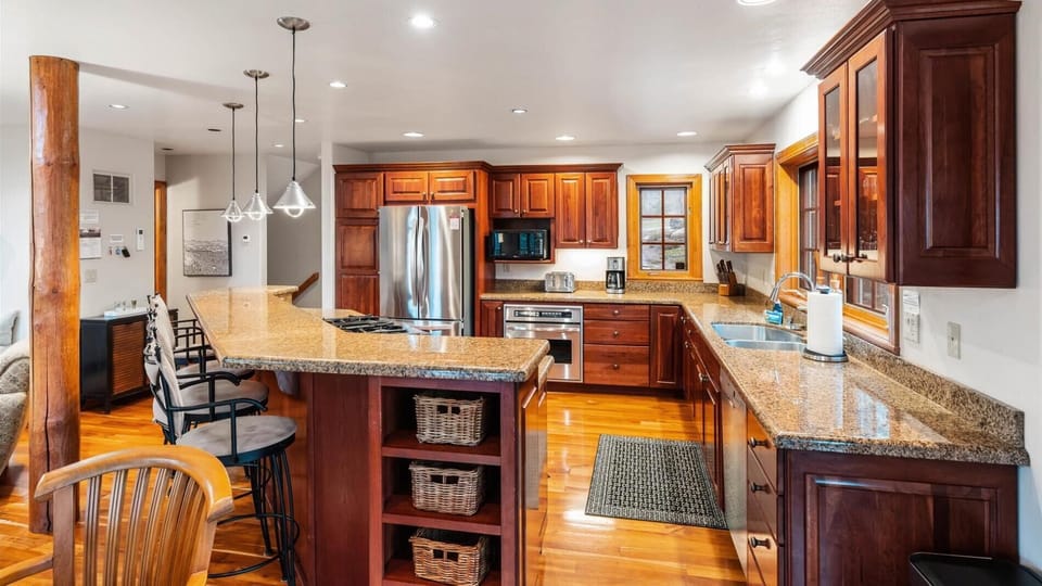 Fully stocked open concept kitchen with breakfast bar seating for 4, two ovens, gas stove, brand new appliances, drip pot coffee maker, and pantry.