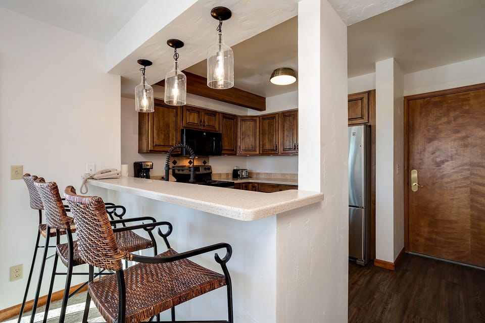 Your open kitchen features rich wood cabinetry, pendant lighting, and a breakfast bar where you can start each morning with coffee.