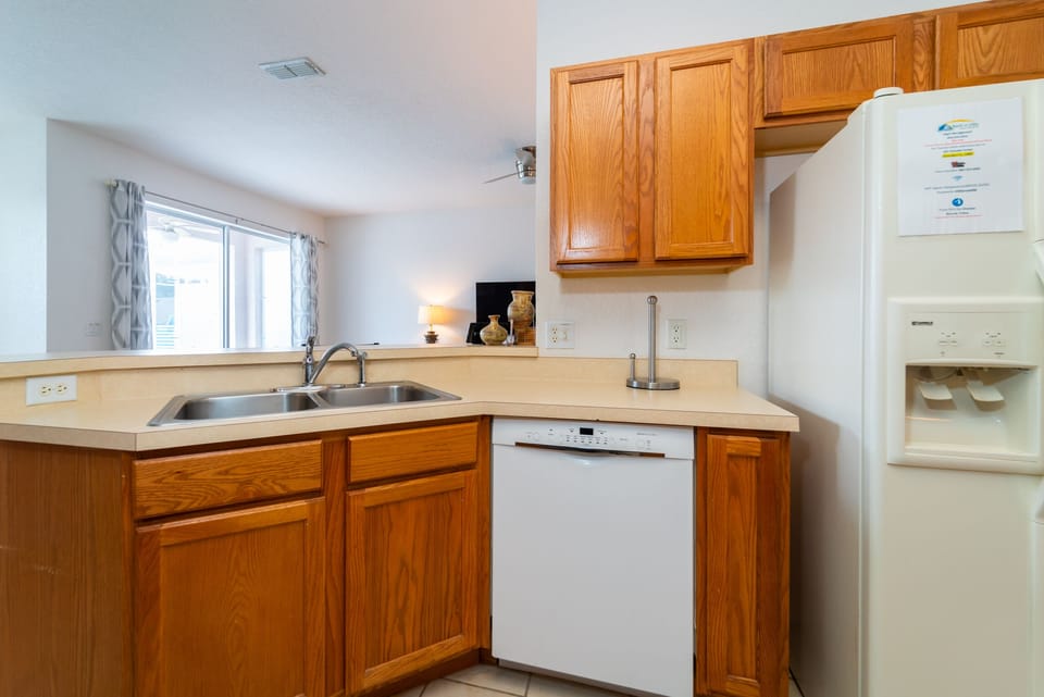 Kitchen counter area with double sink and dishwasher.