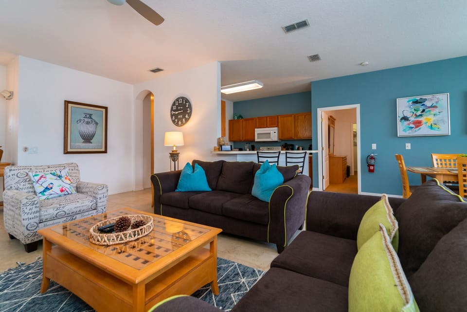 Open concept living room with seating, kitchen view, and dining access.