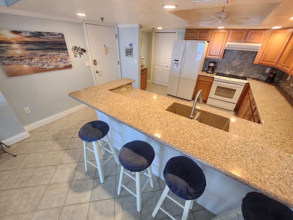 Fully stocked oversized kitchen with granite counters and new appliances.
