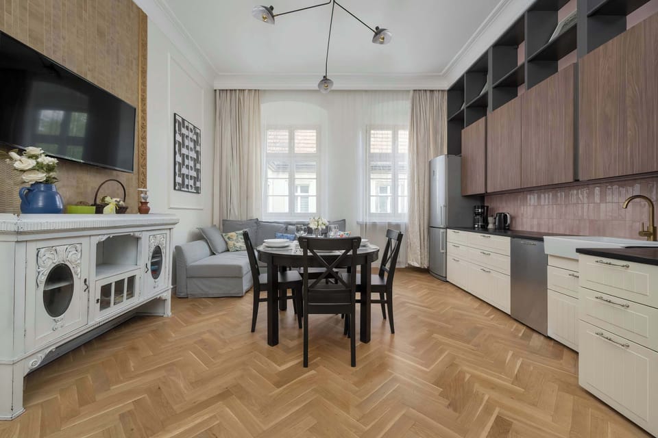 A kitchen and dining setup with classic white cabinets, black chairs, and checkered accents.