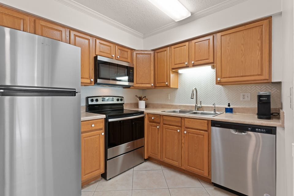 New stainless steel appliances and ceramic backsplash in the kitchen 