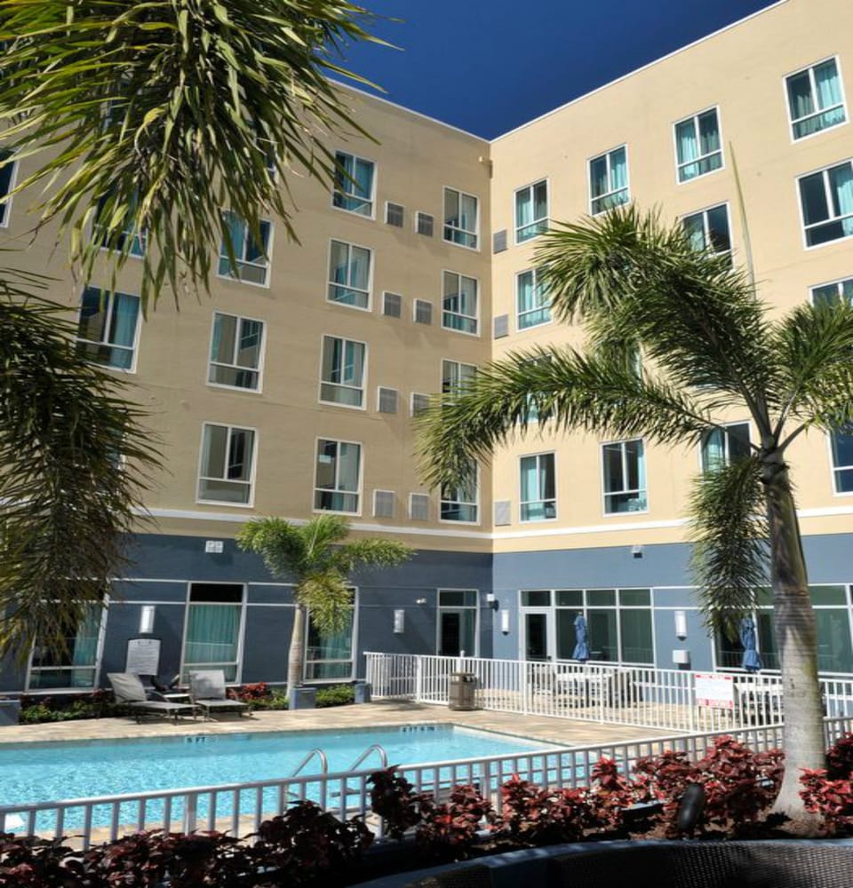 Hotel building exterior with outdoor pool area below.