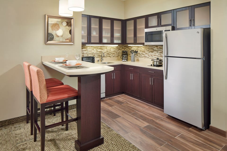 Full kitchen with dark wood cabinets and stainless steel appliances.